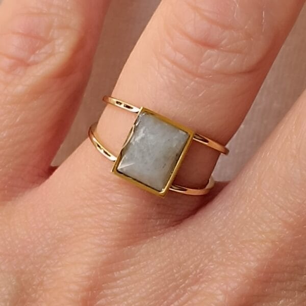 Anillo ERYNA dorado labradorita en mano Anillo ERYNA dorado labradorita en mano