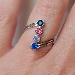 Anillo abierto ERYNA con piedras de colores brillantes colocado en dedo femenino