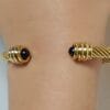 Pulsera rígida dorada ERYNA con piedra negra
