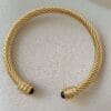Pulsera rígida dorada ERYNA con piedra negra