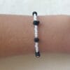 Pulsera ERYNA ajustada en muñeca con cuentas negras y blancas