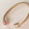 Pulsera rígida dorada ERYNA con piedra rosa