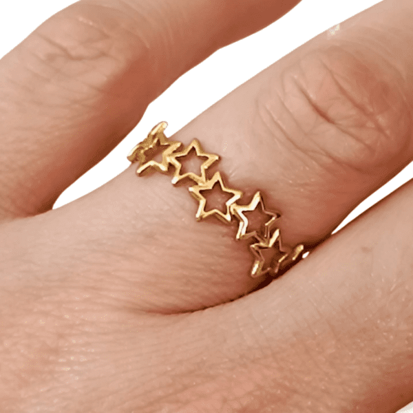 Anillo de estrellas ERYNA en acero dorado colocado en el dedo