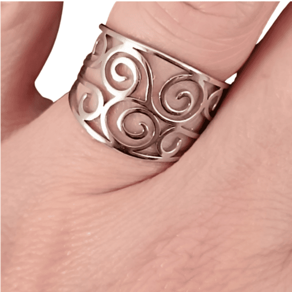 ANILLO ERYNA FILIGRANA ESPIRAL 2 Anillo ERYNA calado con espirales en acero plateado colocado en el dedo