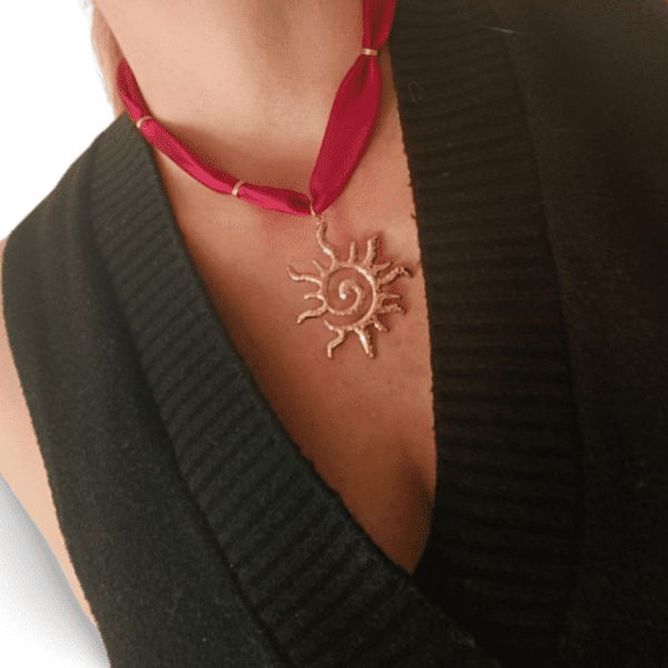 Collar ERYNA sol dorado puesto en cuello de mujer