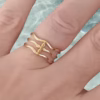 Anillo triple onda floral Eryna en acero dorado puesto en mano