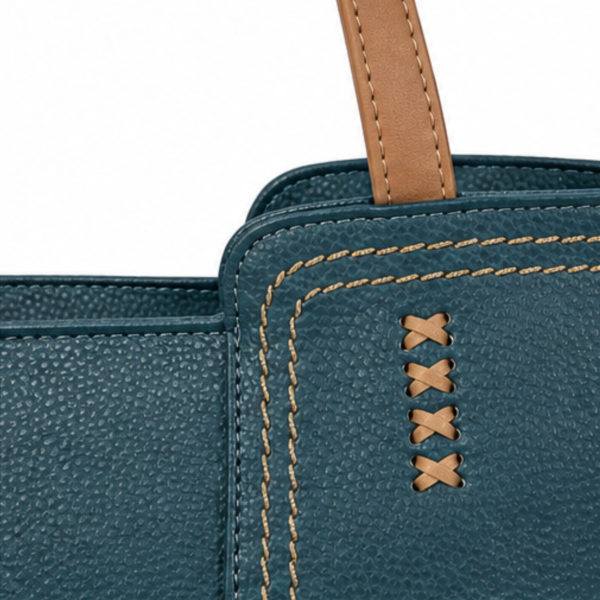 Detalle del asa de tirante marrón y las costuras decorativas del bolso Sara ERYNA en verde azulado