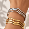 Pulsera ERYNA brazalete ondulado puesto en la muñeca Pulsera brazalete ERYNA de triple banda ondulada puesta en la muñeca