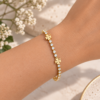 Pulsera ERYNA Dorada Circonitas y Tréboles - Puesta en la Muñeca Pulsera ERYNA de tenis dorada con circonitas y tréboles de cuatro hojas puesta en la muñeca