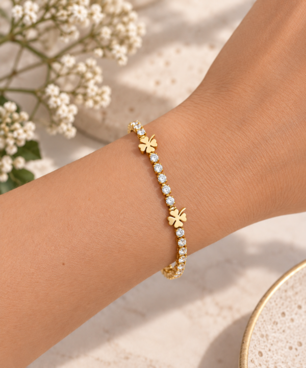 Pulsera ERYNA Dorada Circonitas y Tréboles - Puesta en la Muñeca Pulsera ERYNA de tenis dorada con circonitas y tréboles de cuatro hojas puesta en la muñeca