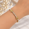 Pulsera dorada árbol de la vida con circonitas - puesta en la muñeca Pulsera dorada con circonitas y motivos del árbol de la vida puesta en la muñeca