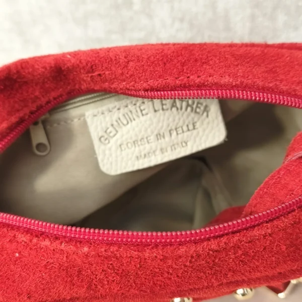 Interior forrado del bolso de ante con bolsillo con cremallera y etiqueta Made in Italy