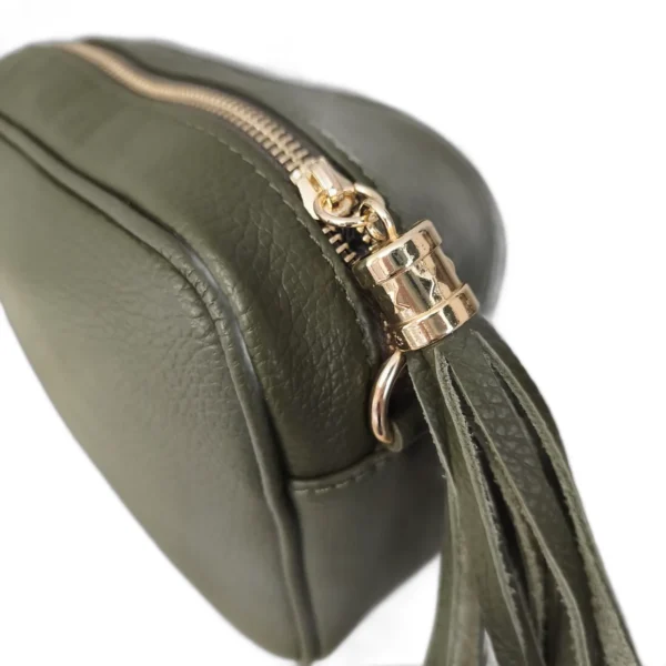 Detalle de la borla y la cremallera del bolso ERYNA de piel Borla de piel con remate dorado en la cremallera del bolso bandolera