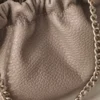 Detalle del frunce del bolso de piel ERYNA Detalle del fruncido y la piel granulada del bolso rosa nude con cadena dorada