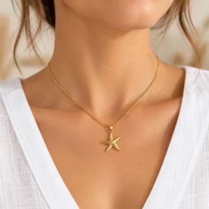 Mujer con collar dorado y colgante de estrella de mar texturizada en acero inoxidable ERYNA