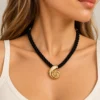Collar ERYNA caracola dorada con cordón negro, puesto Mujer con collar de cordón trenzado negro y colgante de caracola dorada ERYNA