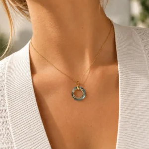 Mujer con collar ERYNA de cadena dorada fina y colgante de anillo de cristal tallado multicolor