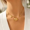 Collar ERYNA corazón y chakras marinos puesto Mujer con collar ERYNA dorado con charms marinos y corazón acanalado