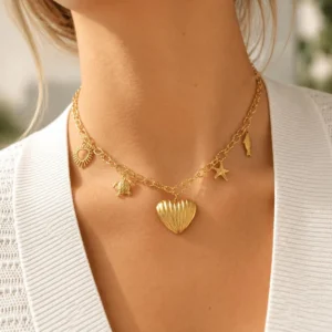 Mujer con collar ERYNA dorado con charms marinos y corazón acanalado