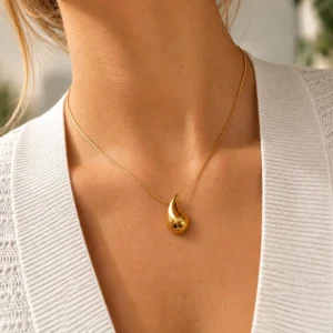 Collar ERYNA gota de acero inoxidable puesto Mujer con collar ERYNA de cadena dorada fina y colgante de gota dorada de acero inoxidable