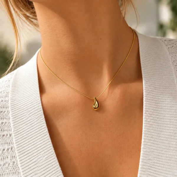 Mujer con collar ERYNA de cadena dorada fina y pequeño colgante de gota dorada