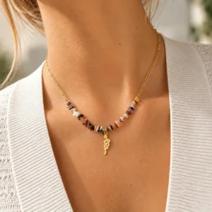 Collar ERYNA piedras naturales con colgante serpiente puesto Mujer con collar ERYNA dorado con piedras naturales de colores y colgante de serpiente dorada
