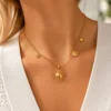 Collar ERYNA sol y chakras marinos puesto Mujer con collar ERYNA dorado con charms marinos y colgante de sol