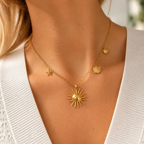Collar ERYNA sol y chakras marinos puesto Mujer con collar ERYNA dorado con charms marinos y colgante de sol