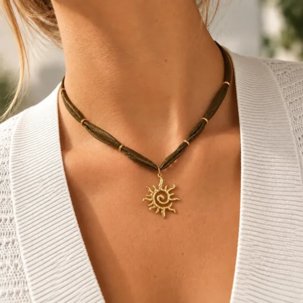 Collar ERYNA sol dorado con cinta textil puesto Mujer con collar ERYNA de cinta textil verde oliva y colgante de sol dorado