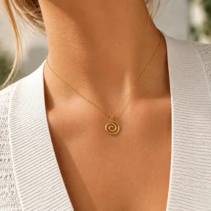Mujer con collar ERYNA de cadena dorada fina y colgante de espiral dorada