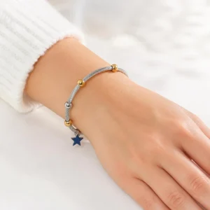 Pulsera ERYNA de acero inoxidable con bolas y colgante puesta en la muñeca