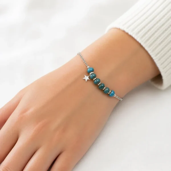 Pulsera de acero inoxidable con cuentas azules y estrella puesta en la muñeca