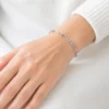 Pulsera de acero inoxidable con eslabones infinito puesta en la muñeca