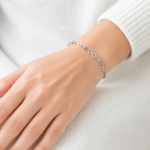 Pulsera de acero inoxidable con eslabones infinito puesta en la muñeca