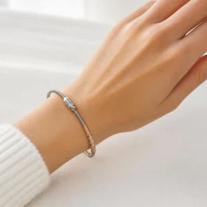 Pulsera ERYNA acero plateado con cristales oro rosa puesta en la muñeca