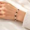 Pulsera ERYNA imitación ágata negra y cristal blanco puesta en la muñeca Pulsera ERYNA imitación ágata negra y cristal blanco puesta en la muñeca