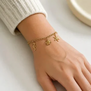 Pulsera ERYNA charms marinos acero dorado puesta en la muñeca Pulsera ERYNA charms marinos acero dorado puesta en la muñeca