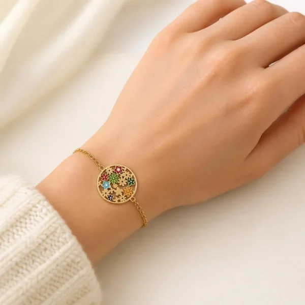 Pulsera ERYNA flor multicolor en acero dorado puesta en la muñeca Pulsera ERYNA flor multicolor en acero dorado puesta en la muñeca