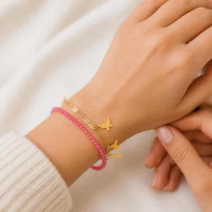 Pulsera ERYNA acero dorado mariposas y cristales negros o rosas puesta en la muñeca