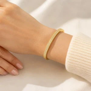 Pulsera ERYNA rígida dorada y plateada de acero inoxidable con doble fila de circonitas puesta en la muñeca