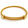 Pulsera ERYNA de hilo trenzado ajustable en color amarillo ocre con terminales dorados